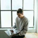 a man sitting on a table reading a book