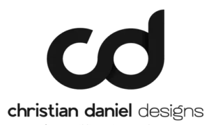 Black logo with lowercase letters "cd" merged together above the right-aligned text "christian daniel designs" in a minimalist, modern font. Features black text on a clean white background for a sleek, contemporary look.